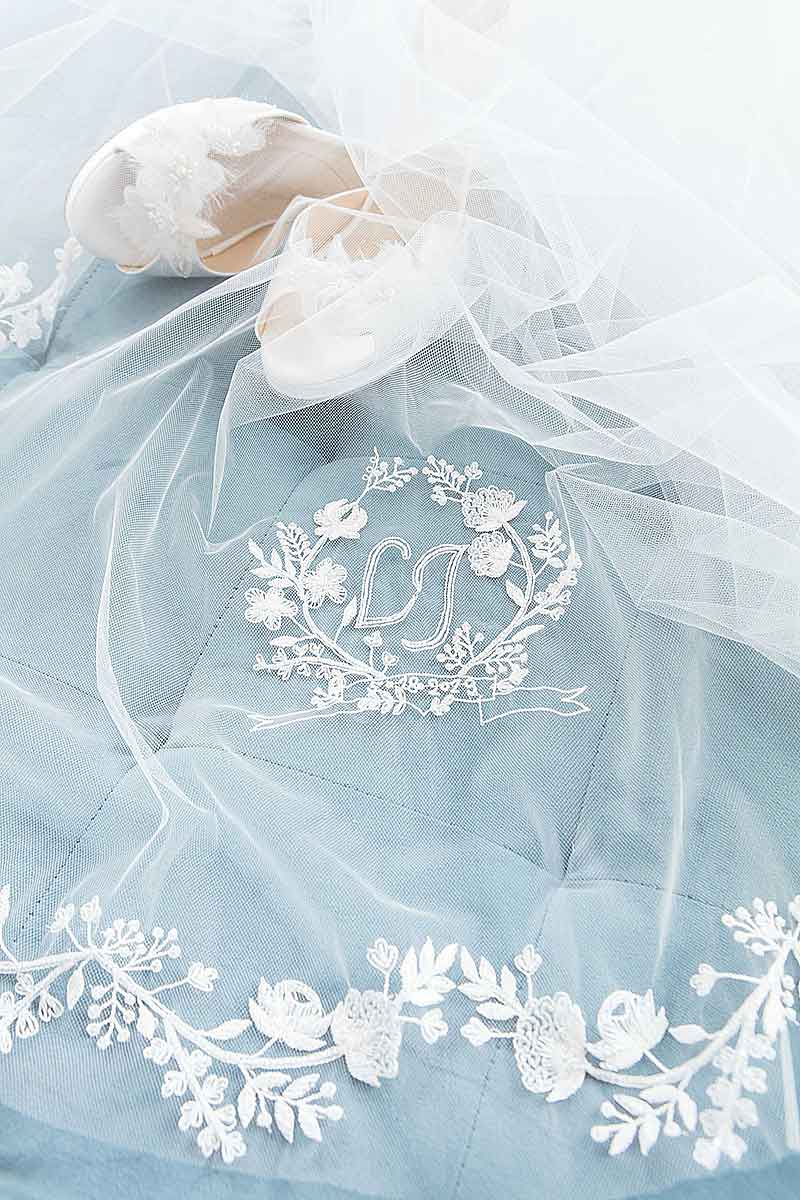 Close up of embroidered floral monogram crest and edging of statement cathedral length veil. Khrysia Monogram Cathedral Veil. Made in Canada by Laura Jayne Accessories Toronto. 