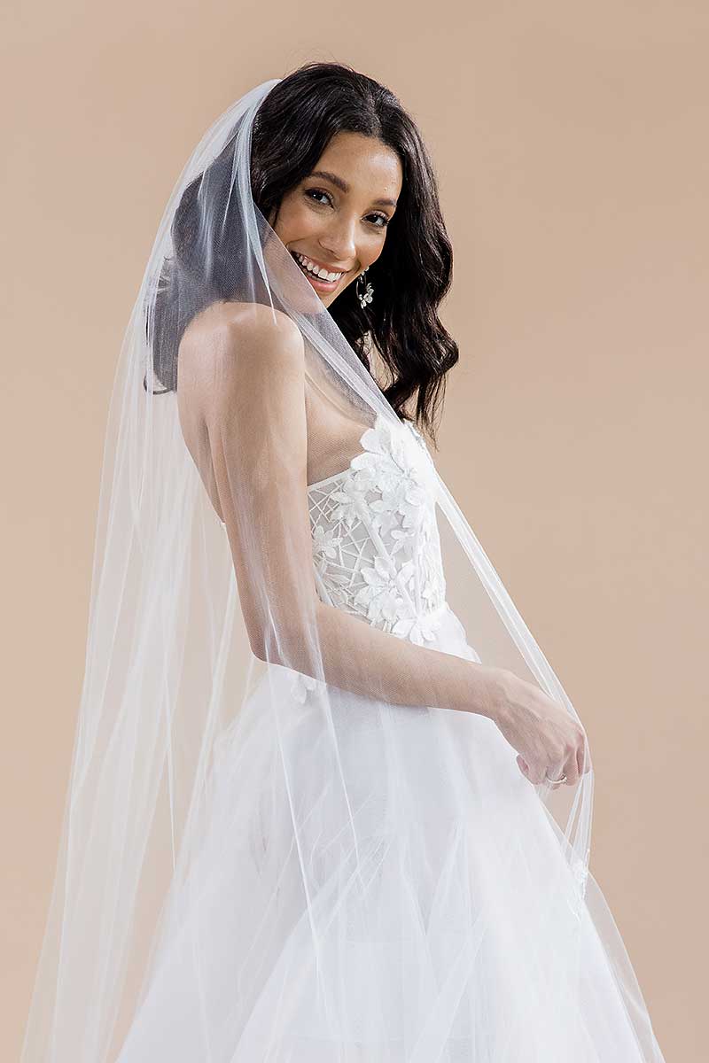 Portrait of a modern romantic bride wearing a long, sheer, cathedral length wedding veil with beaded flower blossoms. Monet Beaded Blossom Cathedral Veil by Laura Jayne Accessories Toronto. Made in Canada. Portrait of 