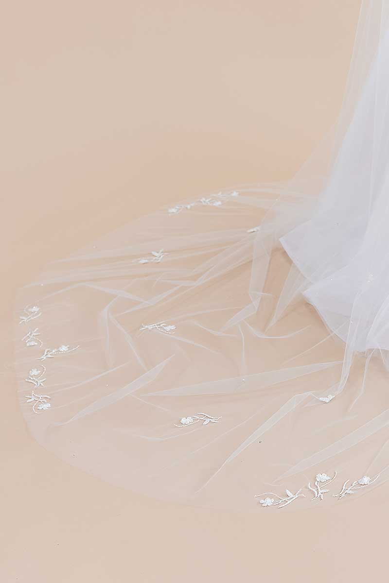 A close up view of the delicate hand-beaded blossom details found on the sides and train of the Monet Beaded Blossom Cathedral Veil from Laura Jayne Accessories Toronto. Handcrafted in Canada.
