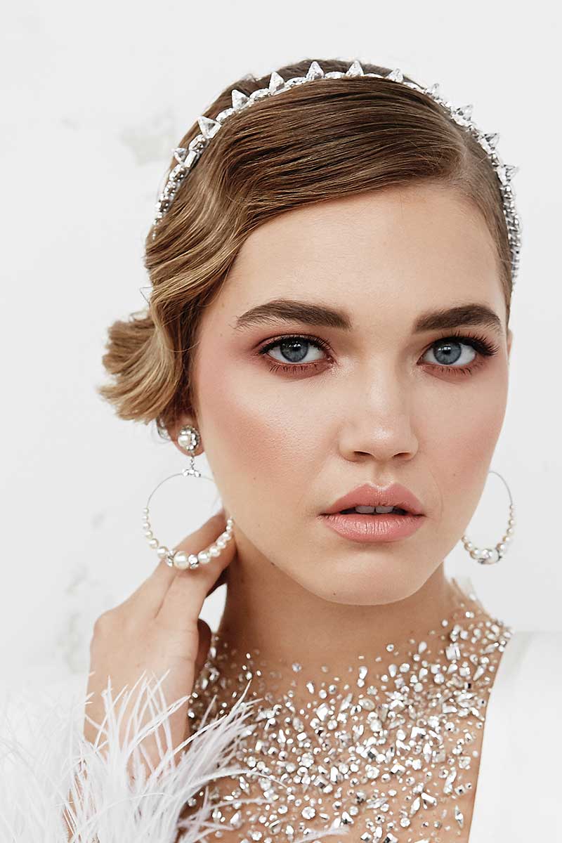 Woman wearing Laura Jayne crystal spike headband and modern pearl hoop earrings