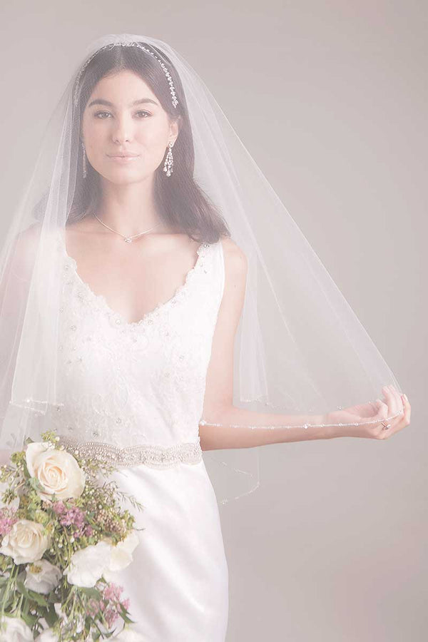 Modern bride wearing a classic chapel length blusher veil over her face. Leanna Crystal Edge Chapel Veil by Laura Jayne. Handcrafted in Toronto, Canada.
