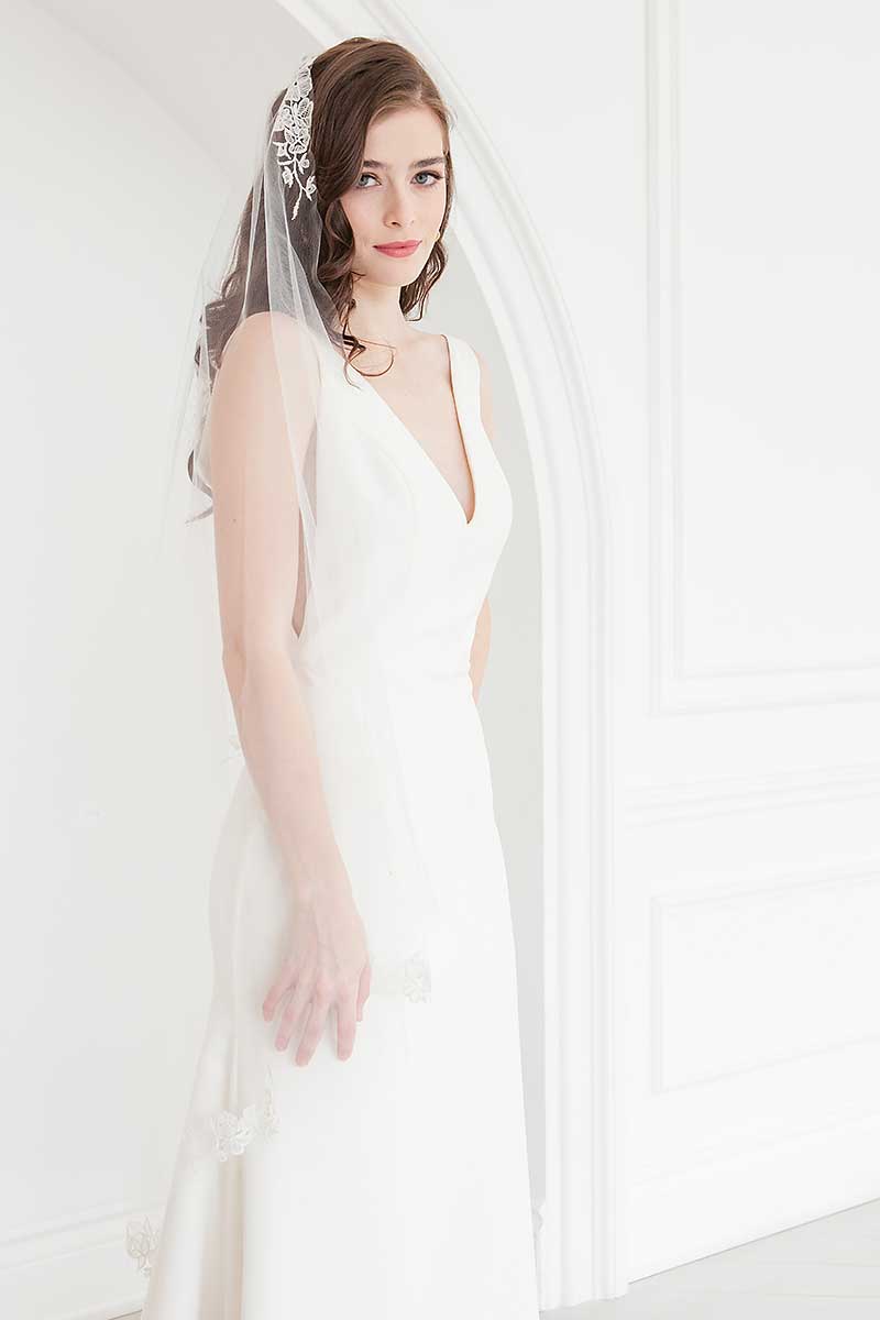 Portrait of bride wearing waltz length mantilla veil with flower appliques. Rosalie Mantilla Veil by Laura Jayne accessories. 