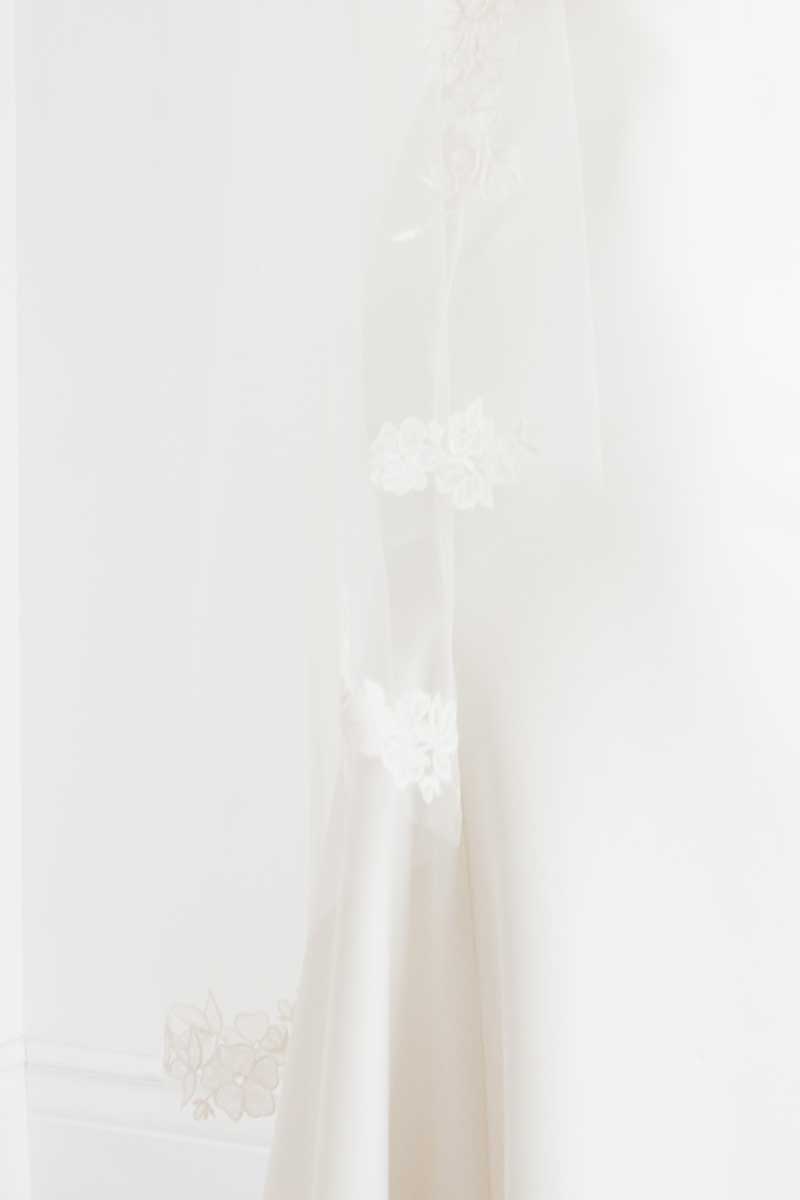 Close up view of hand embroidered flowers found at the sides of the Rosalie Mantilla Veil by Laura Jayne.