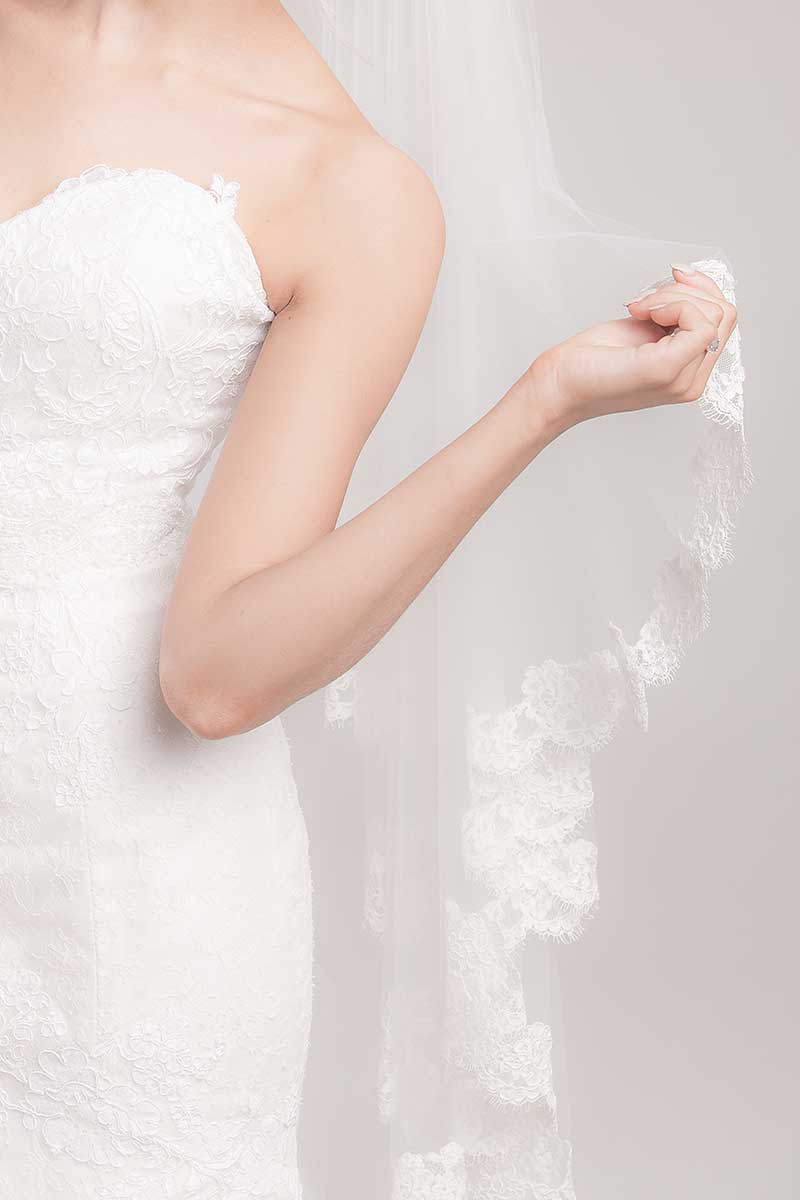 Bride holding French lace edge of Laura Jayne Marlisa fingertip veil. Handcrafted in Toronto, Canada. 