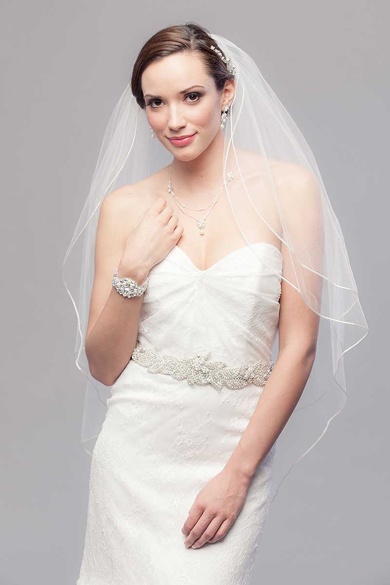 Modern romantic bride wearing classic fingertip length wedding veil with blusher and metallic cord edge. Opulence Two Tier Fingertip Veil by Laura Jayne Accessories Toronto. Handcrafted in Canada.