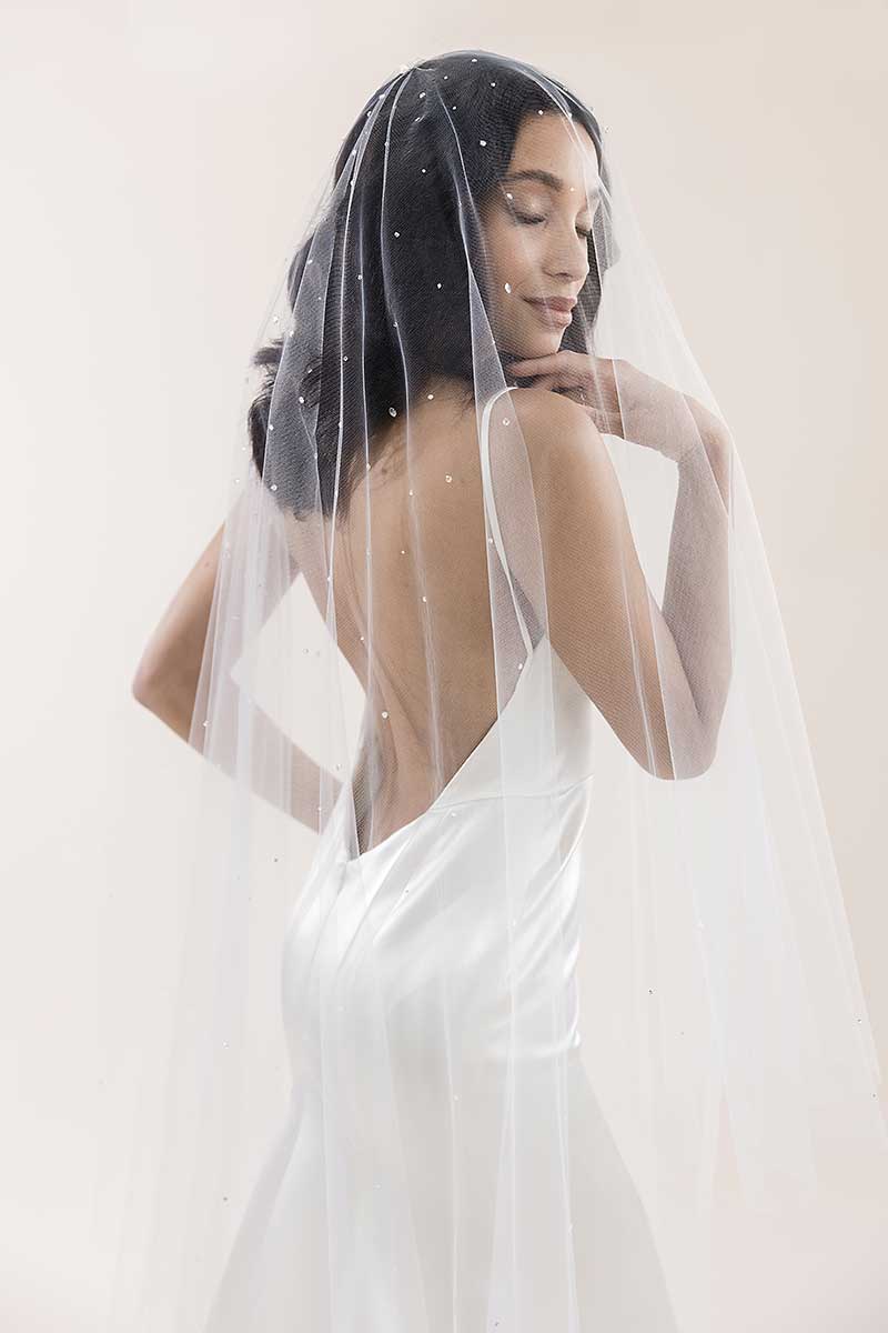 Profile of bride with blusher veil over her face wearing Rain crystal waltz length veil by Laura Jayne Accessories. Handcrafted in Toronto, Canada.