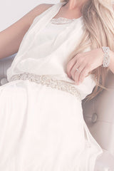 seated bride with textured wedding dress sash and silver cuff