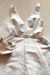Flat lay of wedding dress with Amafi sash Angela Nuran shoes and face veil 