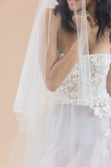 close-up bodice of bride wearing 2 tier cathedral veil with blusher veil over face