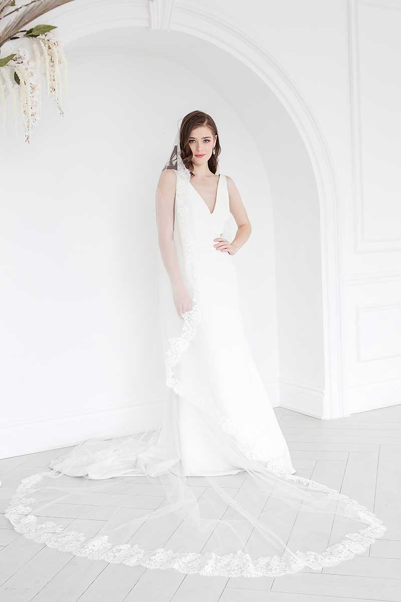 Front view of the Peyton Mantilla Cathedral veil's full train on bride.