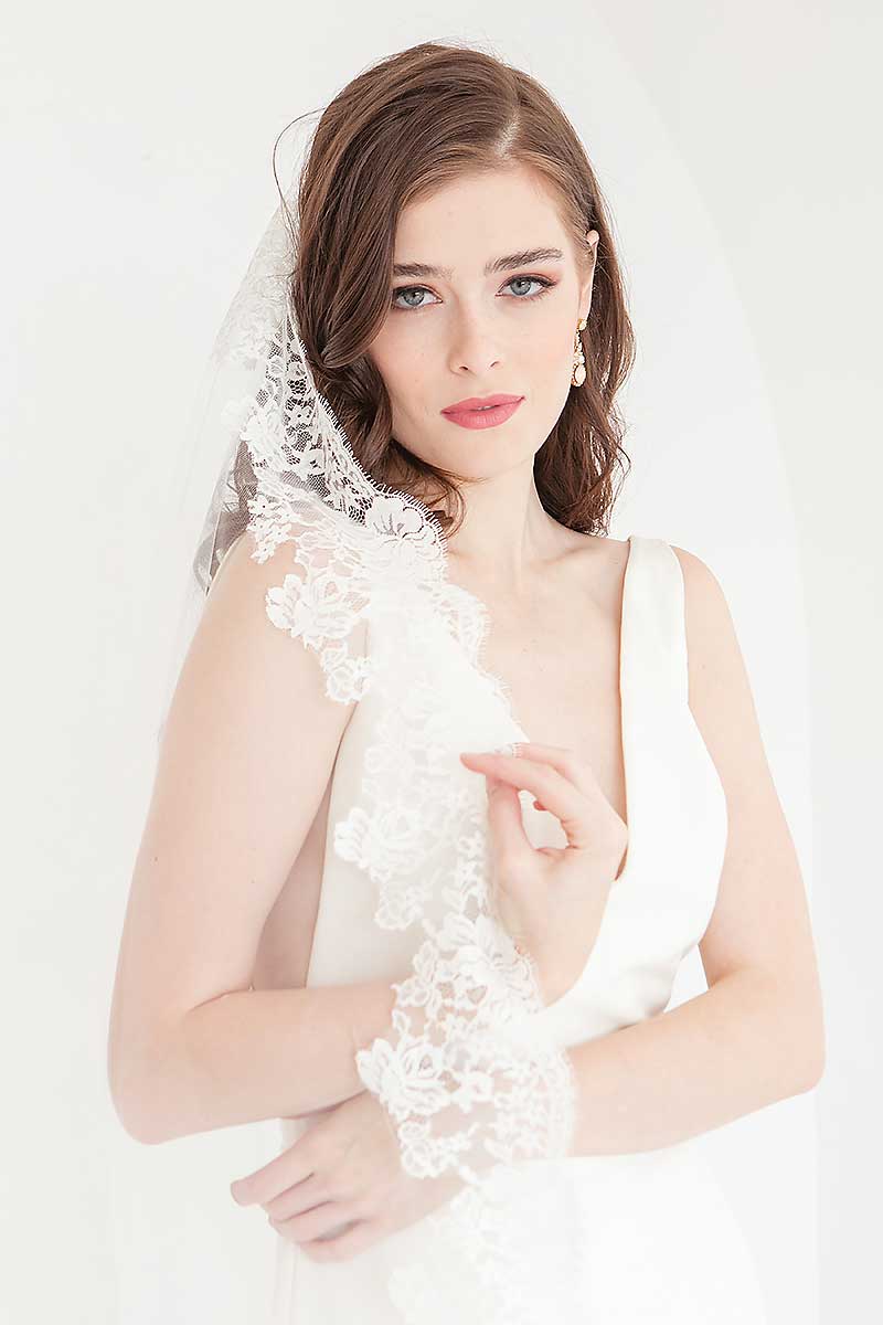 Front view of bride wearing Peyton cathedral length mantilla wedding veil.