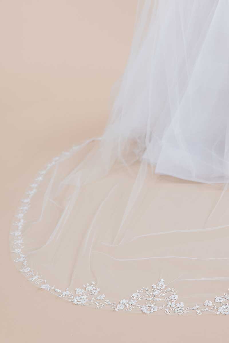 Close up view of the hand-beaded floral details at the centre and sides of our Bisous cathedral length wedding veil. Laura Jayne Accessories Toronto. Handcrafted in Canada.