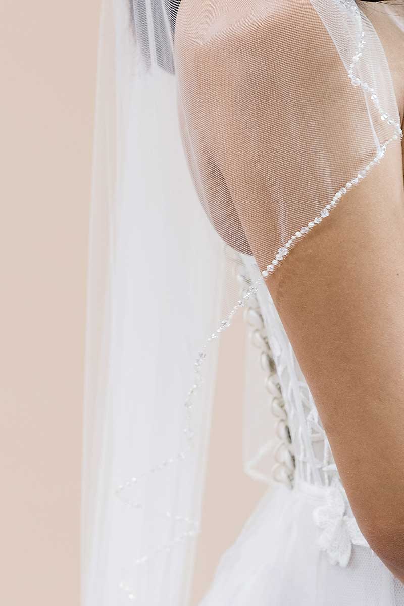 Closeup of crystal beaded edge detail on Laura Jayne Dea cascade fingertip length veil by Laura Jayne Accessories Toronto. Handcrafted in Canada.