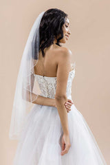 Back of woman wearing Dea fingertip crystal edge cascade cut veil by Laura Jayne Accessories. Handcrafted in Canada.