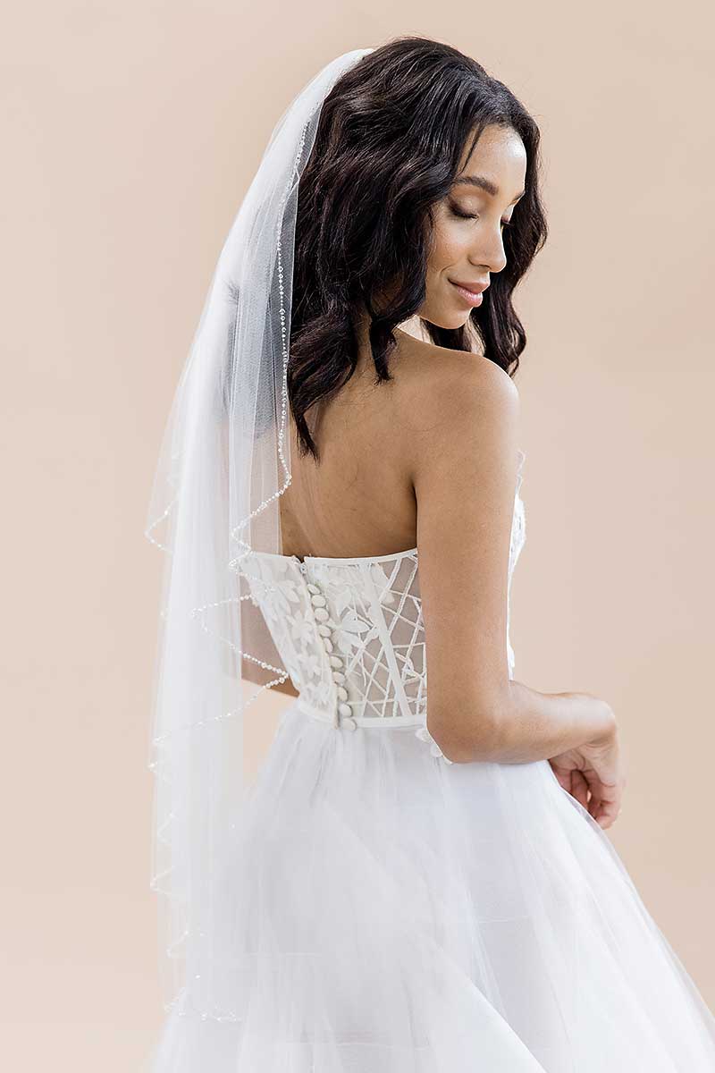 Profile of woman looking down wearing Dea cascade crystal edge veil by Laura Jayne Accessories Toronto. Handcrafted in Canada.