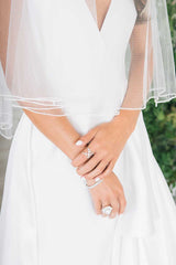 Bodice of bride wearing Laura Jayne Jess fingertip beaded edge veil