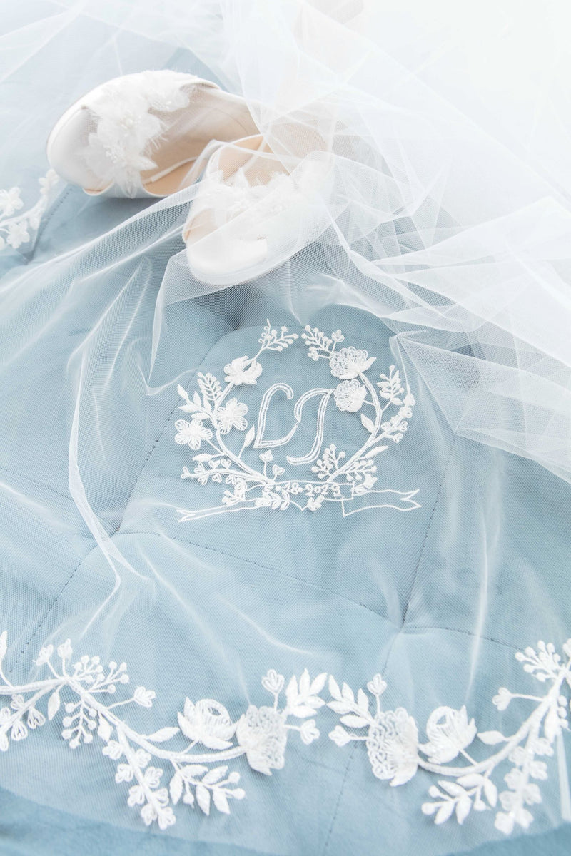 Close up of embroidered floral monogram crest and edging of statement cathedral length veil. Khrysia Monogram Cathedral Veil. Made in Canada by Laura Jayne Accessories Toronto. 