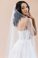 Side view of modern bride looking back with her long cathedral length veil draped over one shoulder. Nera 3D Flower Cathedral Veil made in Canada by Laura Jayne Accessories Toronto..
