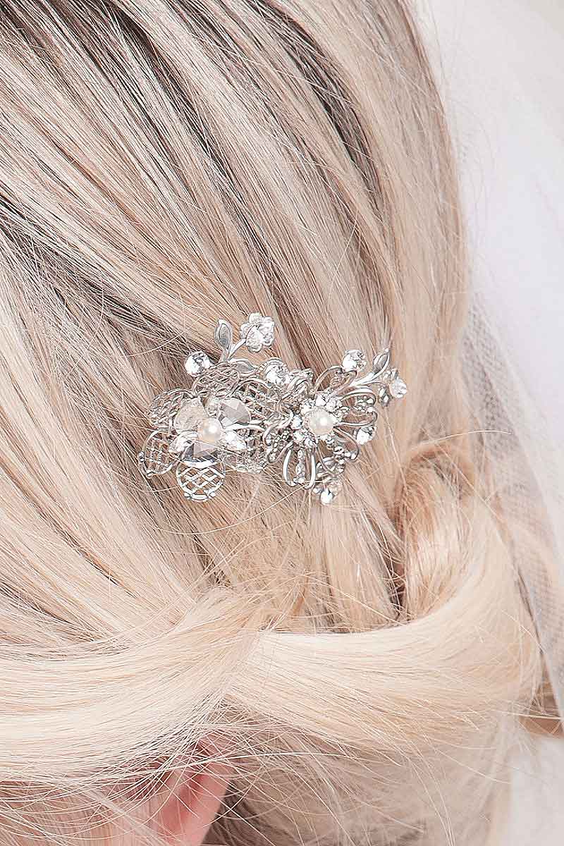 Sparkling and whimsical this bridal comb feature filigree blossoms and vines accented with crystal stones and pearls. Finished on a wire tooth metal comb.