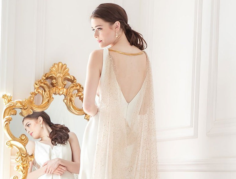 Back profile of woman wearing glitter cathedral veil cape in rose gold for wedding. Adryn Cathedral Cowl Veil Cape by Laura Jayne. Handcrafted in Toronto, Canada.