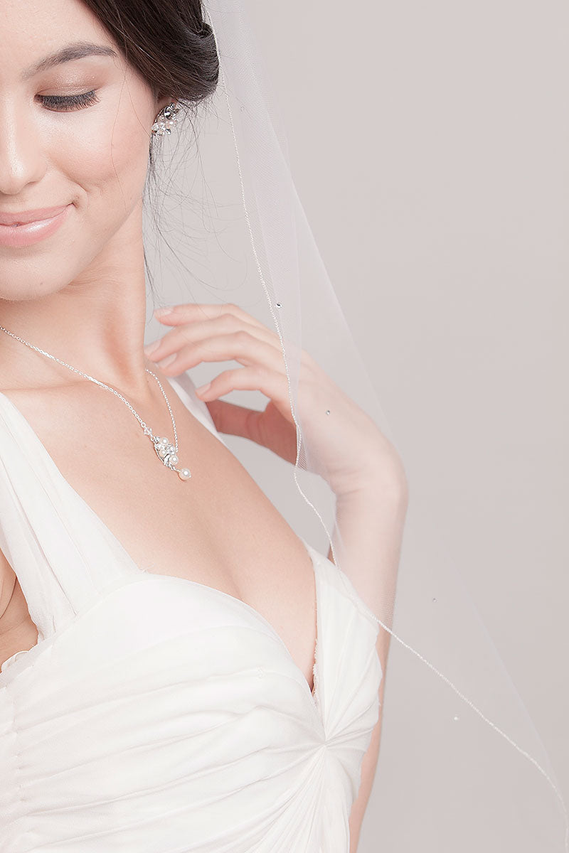 A closeup view of the crystal details framing the edge of this whimsical, romantic Cerie Fingertip Juliet Veil by Laura Jayne. Made in Toronto, Canada.