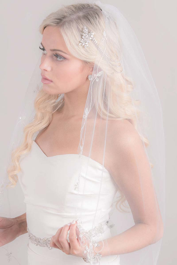 Modern romantic bride wearing a whimsical boho inspired sheer classic cut tulle fingertip length wedding veil. Constance Vine Embroidery Fingertip Veil. Made in Canada by Laura Jayne Accessories Toronto.