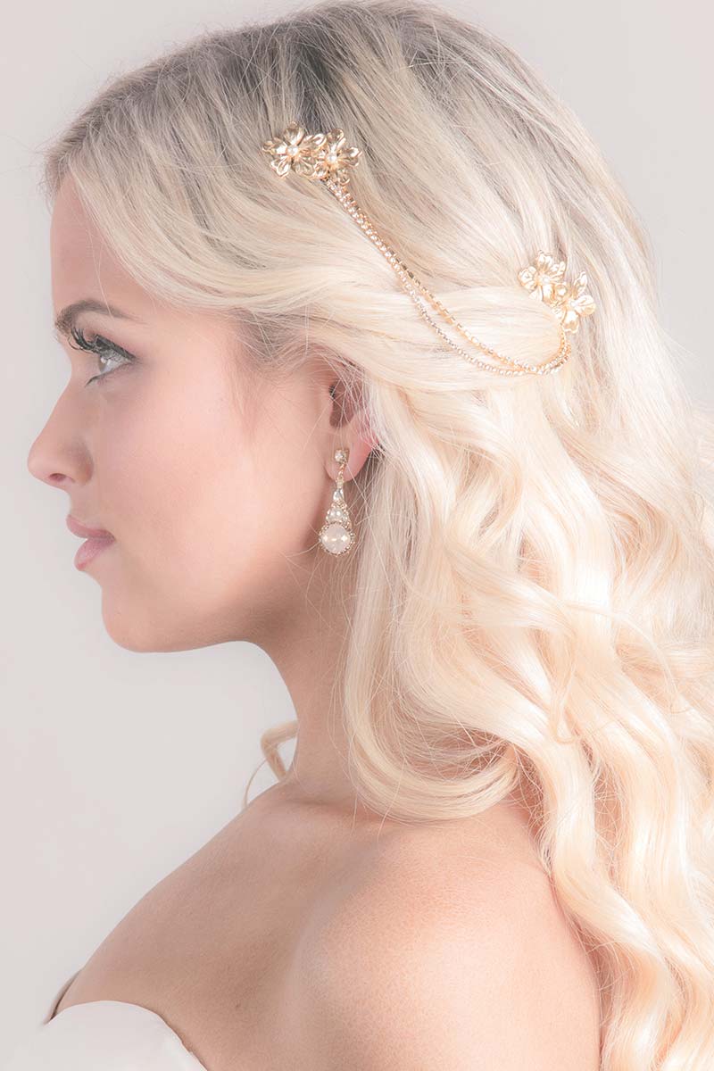 Profile of woman with beachy waves hairstyle and chain headpiece with gold blossoms