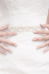 Bride with hands on waist wearing Verde gold leaf wedding belt by Laura Jayne