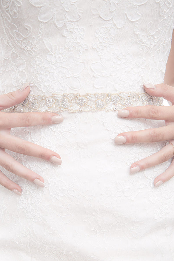 Bride with hands on waist wearing Verde gold leaf wedding belt by Laura Jayne