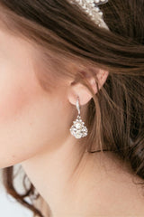 closeup of a bride wearing a tear drop earring with crystals and a pearl