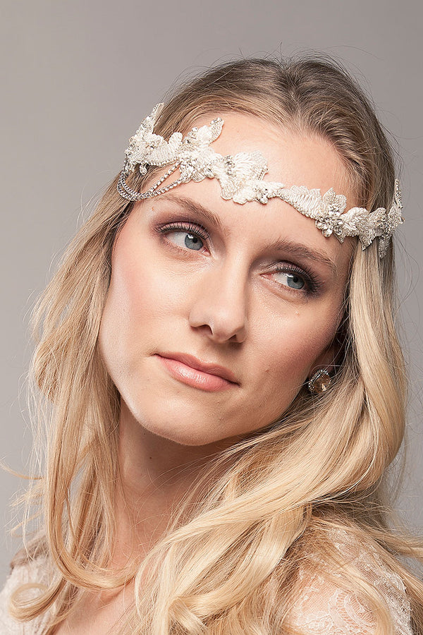 Woman wearing beaded headband bridal hairpiece with side draped chain detail