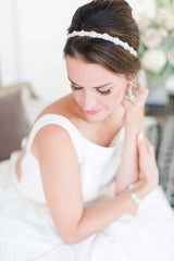 Bride seated with head down wearing beaded hair ribbon accessory by Laura Jayne