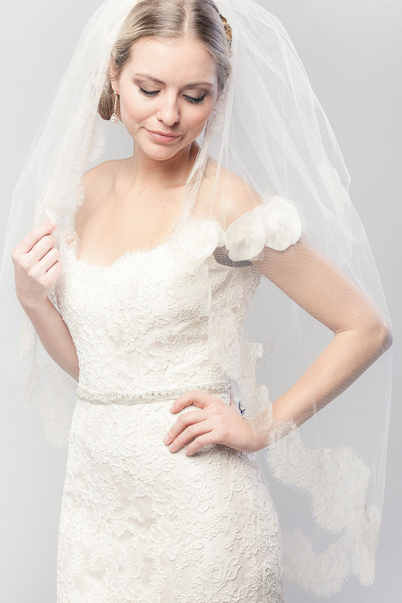 Modern bride looking down wearing a two tier fingertip length blusher veil with lace edge. Coco Chantilly Fingertip Cage Veil by Laura Jayne Accessories Toronto. Handcrafted in Canada.