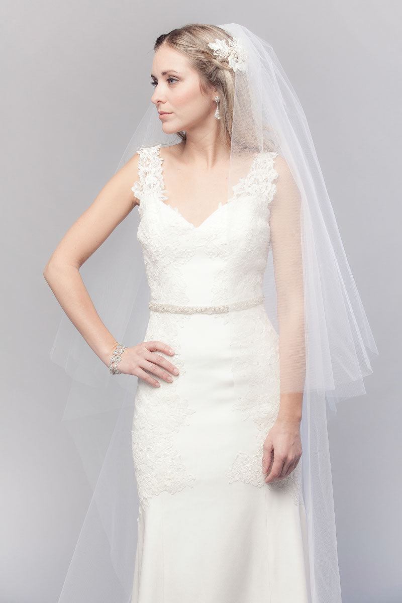 Wider view of modern romantic bride with head turned to side wearing a timeless classic two-tier cathedral wedding veil. Mae Cathedral Veil with blusher handcrafted in Canada by Laura Jayne Accessories Toronto.