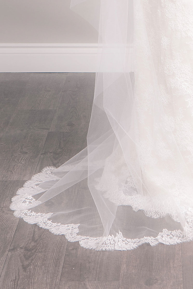 Close up of French lace with rose pattern on blush pink Bree Chapel Length Chantilly Lace Veil by Laura Jayne. Made in Toronto, Canada.