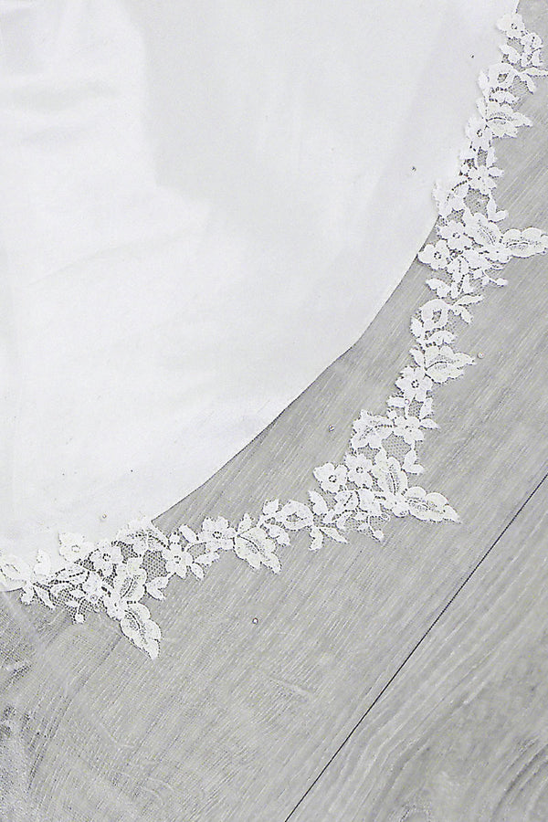 Close up view of handpainted French Chantilly lace detail around the edge of the Romantique Lace Cathedral Veil by Laura Jayne. Handcrafted in Toronto, Canada.