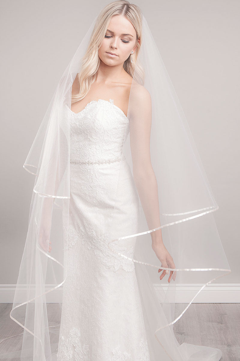 Bride looking down wearing ribbon edge cathedral veil Miranda by Laura Jayne Accessories Toronto. Handcrafted in Canada.