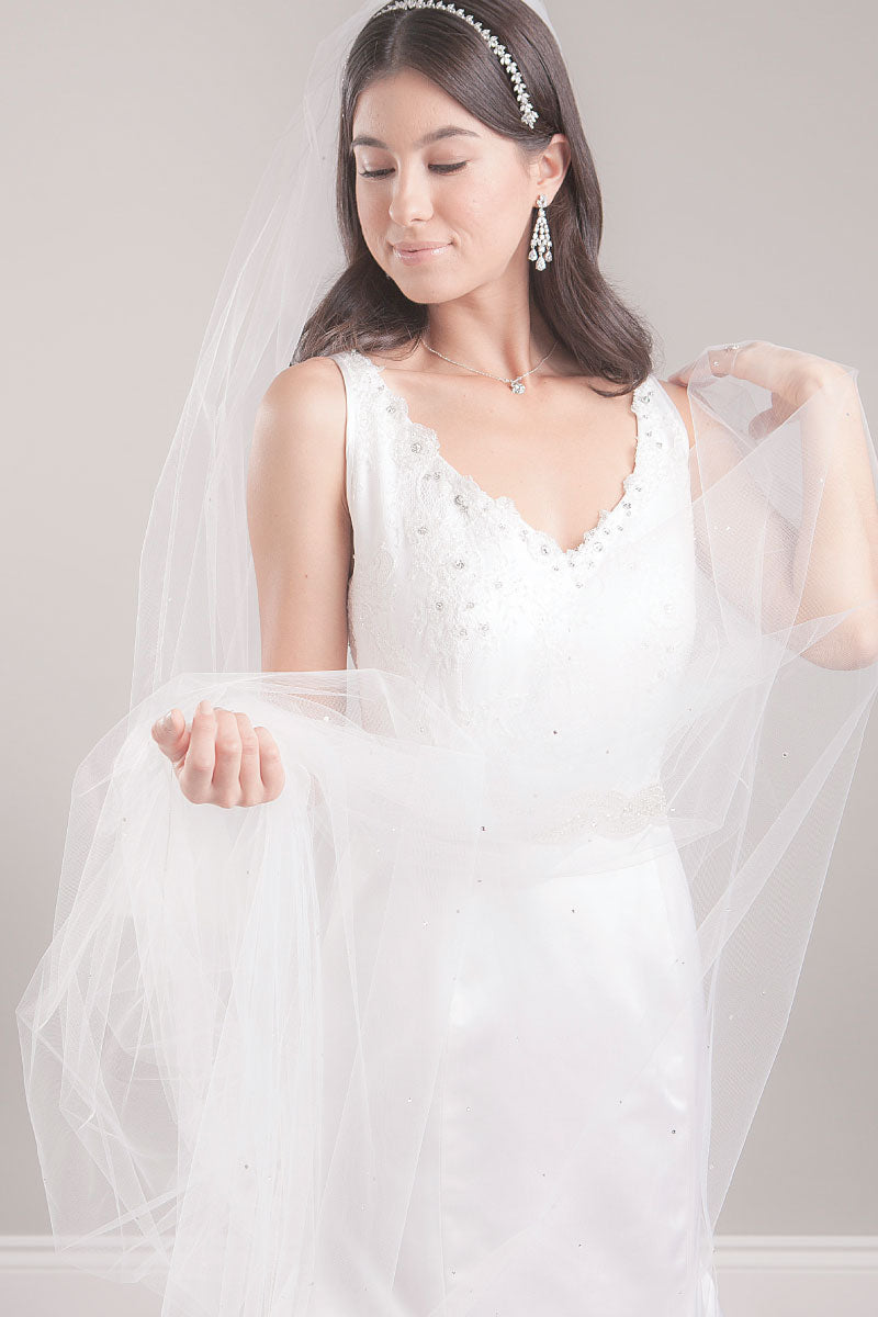 Profile of modern romantic bride wearing a pretty cathedral length tulle veil with crystals and "Love" monogram. Cherish Crystal Cathedral Veil by Laura Jayne Accessories Toronto. Handcrafted in Canada. 