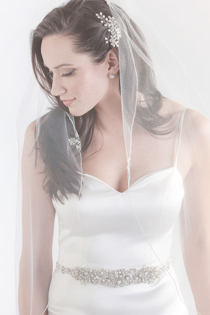 Bride with face turned to the side wearing Lavinia single tier beaded fingertip length veil by Laura Jayne. Handcrafted in Toronto, Canada. 